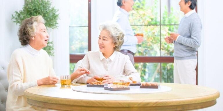 Elderly Friends Sharing Food During Seasonal Retirement Community Gathering
